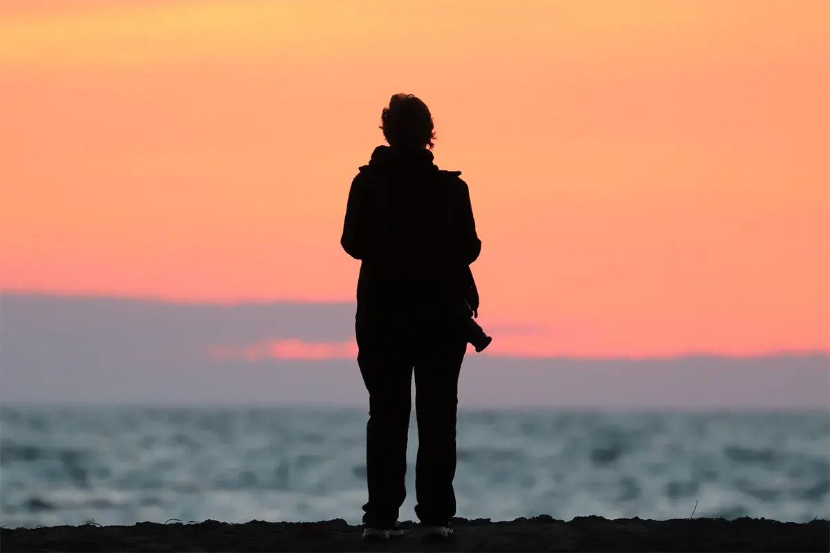 A silhouette of Karen Morton at the beach.